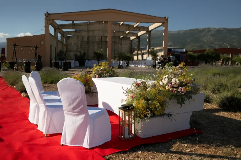 Outdoor wedding or event setup with decorated chairs, flowers, and a red carpet at Morlacco venue.